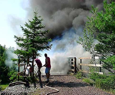 Firefighters spray water on the burning railway bridge in Wallace on 11 August 2002